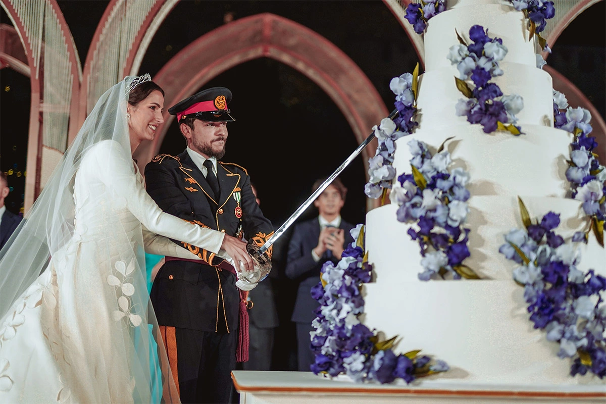 <p>Принцесса Раджва и принц Хусейн разрезают свадебный торт в финале торжественного ужина по случаю свадьбы&nbsp;во дворце Аль-Хусейния</p>