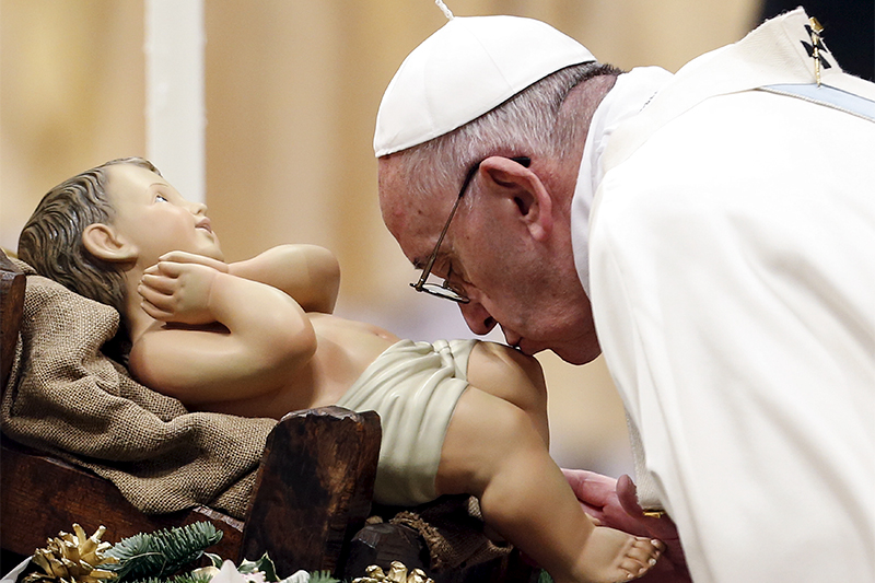 Папа римский Франциск целует статую младенца Иисуса в Соборе св. Петра в Ватикане
