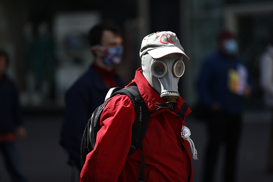 Один из участников первомайской акции протеста в Берлине, использующий в качестве средства защиты противогаз
