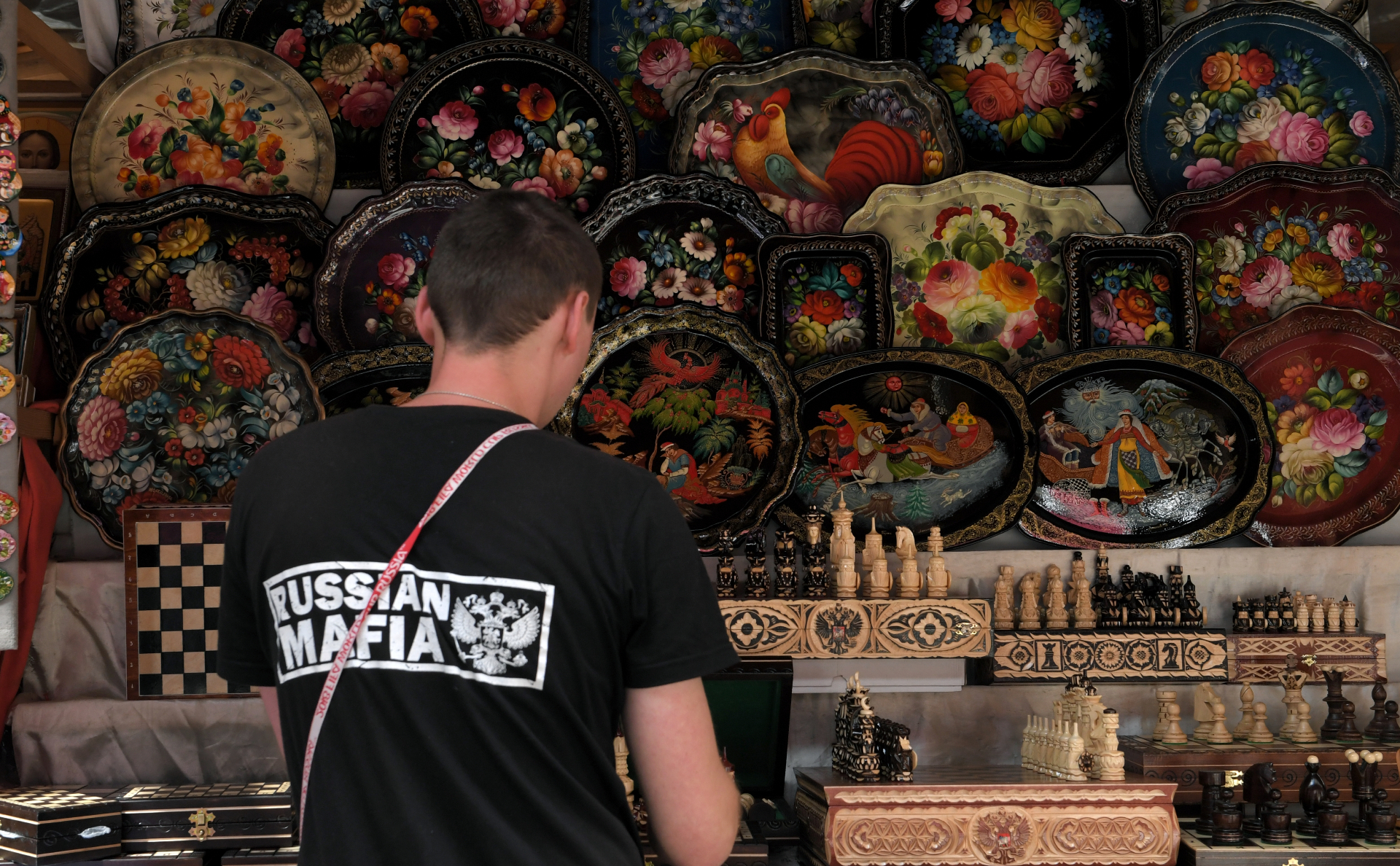 Турист рассматривает сувениры в Измайловском кремле в Москве