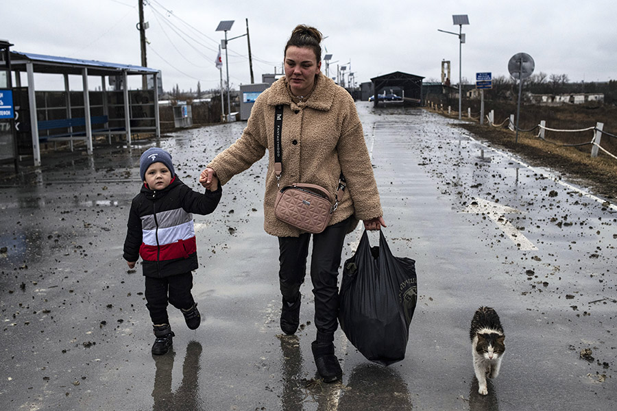 Женщина с ребенком идут по дороге у Станицы Луганской, перешедшей под контроль ЛНР, 26 февраля