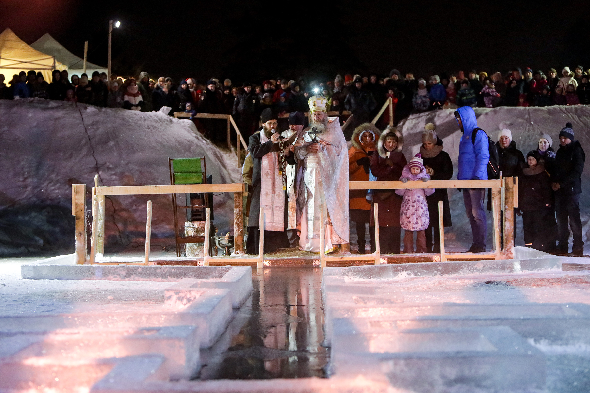 Священнослужители во время освящения воды в купели на пруду в поселке Тярлево, Санкт-Петербург