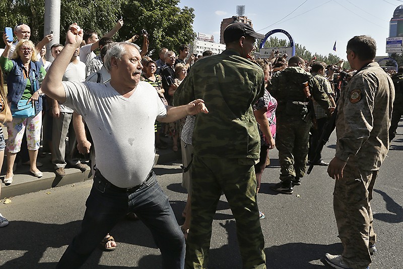 Жители Донецка кидали в проходящих в колонне пленных камнями и мукой, поливали их водой. 