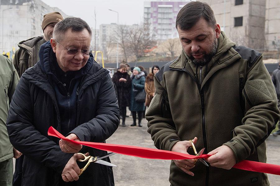 Министр строительства и ЖКХ России Ирек Файзуллин и временно исполняющий обязанности главы Донецкой Народной Республики Денис Пушилин перерезают ленту на торжественной церемонии вручения ключей от новых квартир в Мариуполе, 2022 год