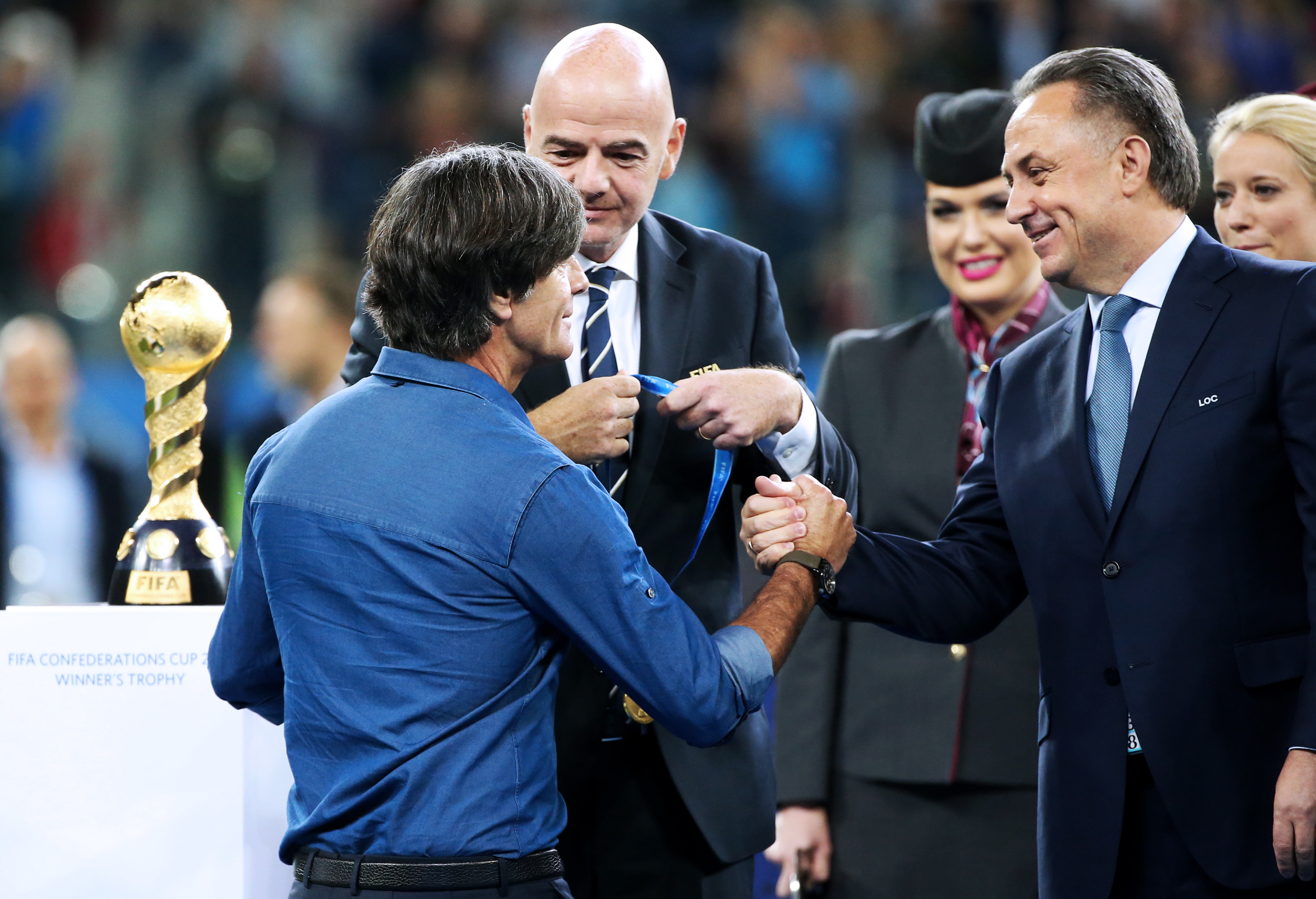 Главный тренер сборной Германии Йоахим Лев (крайний слева) получает поздравления от президента ФИФА Джанни Инфантино (в центре) и главы РФС Виталия Мутко