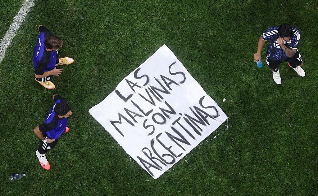 Футболисты сборной Аргентины на фоне баннера &laquo;Las Malvinas son Argentinas&raquo;