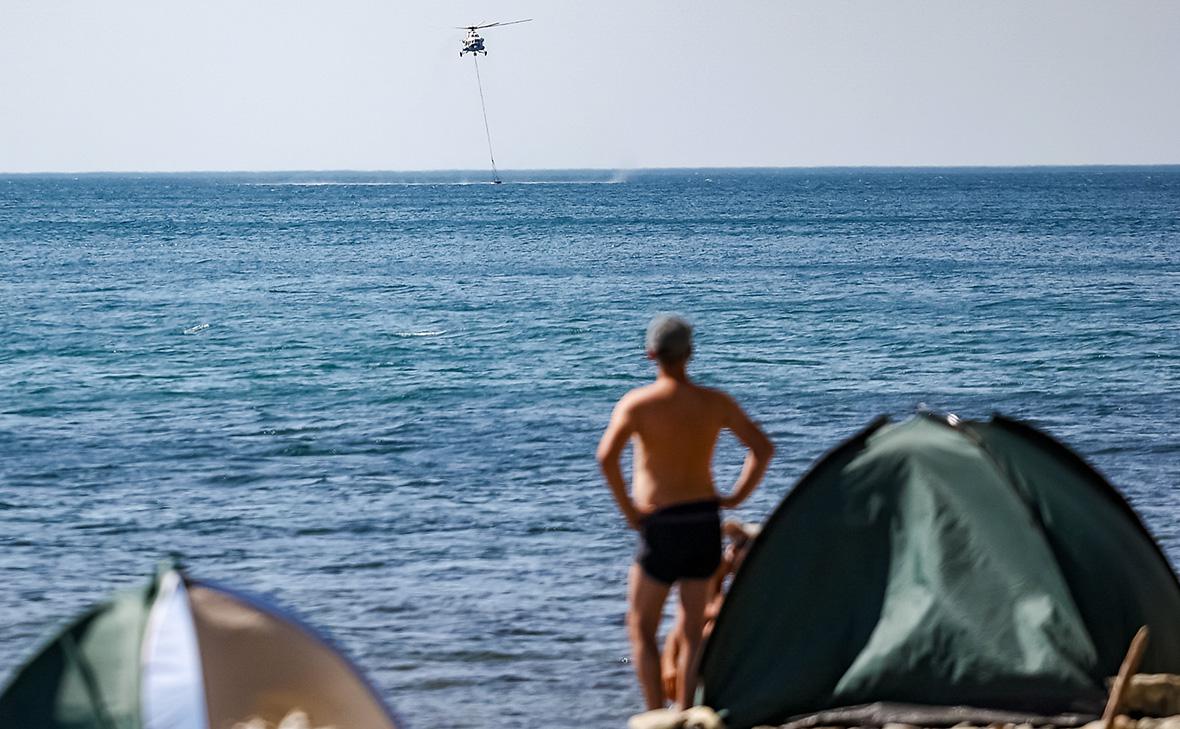Вертолёт Ми-8 МЧС России набирает воду для тушения крупного лесного пожара на территории Пшадского лесничества под Геленджиком в Краснодарском крае