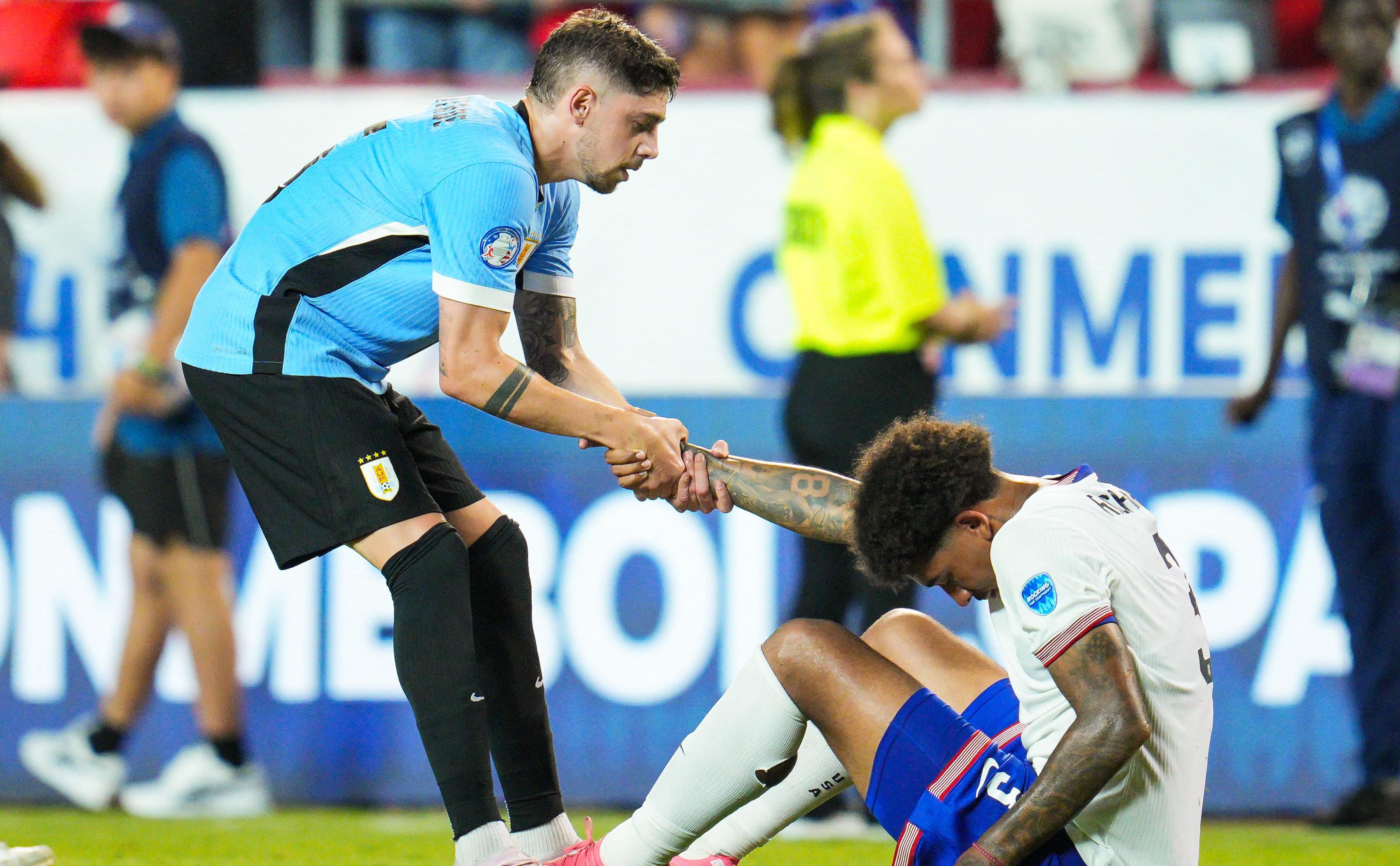 Полузащитник сборной Уругвая Федерико Вальверде утешает защитника команды США по футболу Криса Ричардса