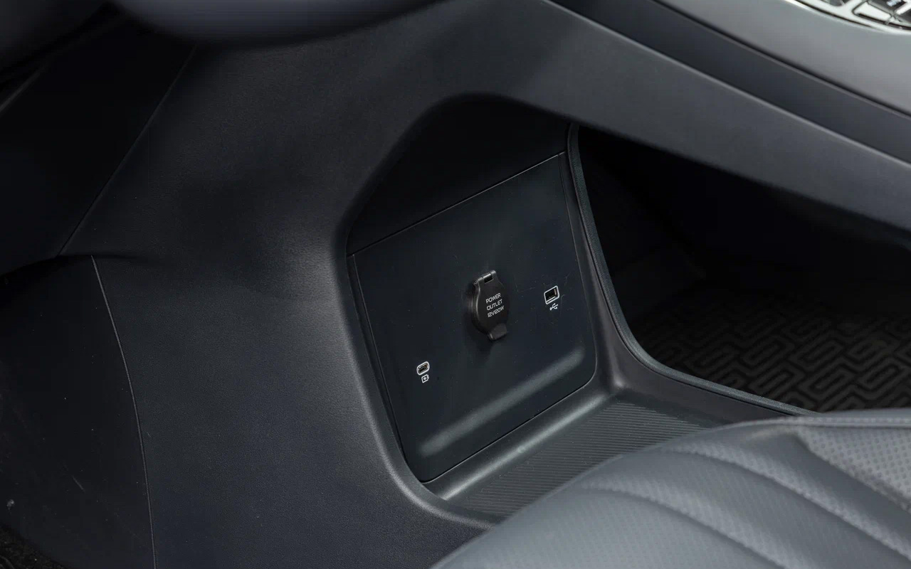 На нижнем ярусе центральной консоли в Geely EX5 EM-i прячутся розетка на 12 В и пара USB-разъемов