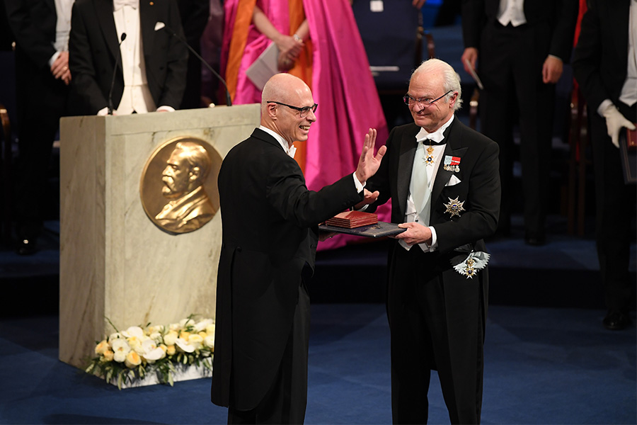 Нобелевскую премию по физике получил Артур Эшкин из США за изобретение оптического пинцета. На церемонию вместо 96-летнего ученого приехал его сын Майкл (на фото слева)
