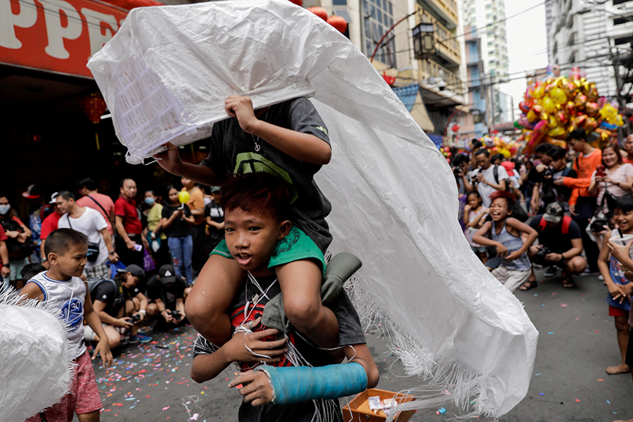 Дети исполняют импровизированный танец дракона во время празднования китайского лунного Нового года в Чайна-тауне, Манила (Филиппины)