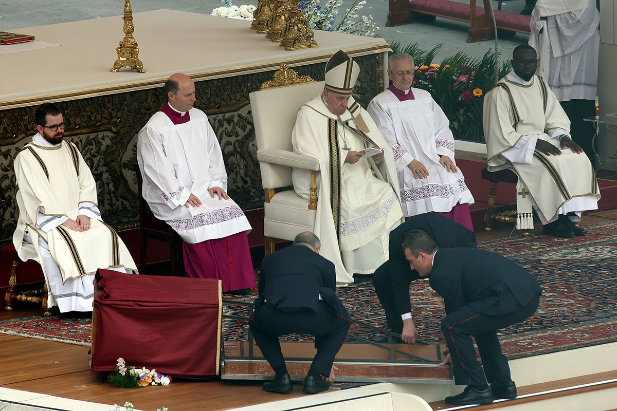 <p>Служители в Ватикане поднимают упавшую во время пасхальной мессы икону</p>