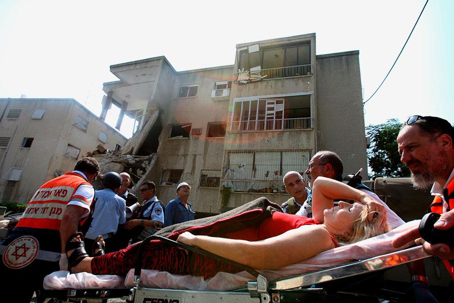 Раненых увозят после ракетного удара &laquo;Хезболлы&raquo; по израильскому городу Хайфа, 17 июля 2006 года