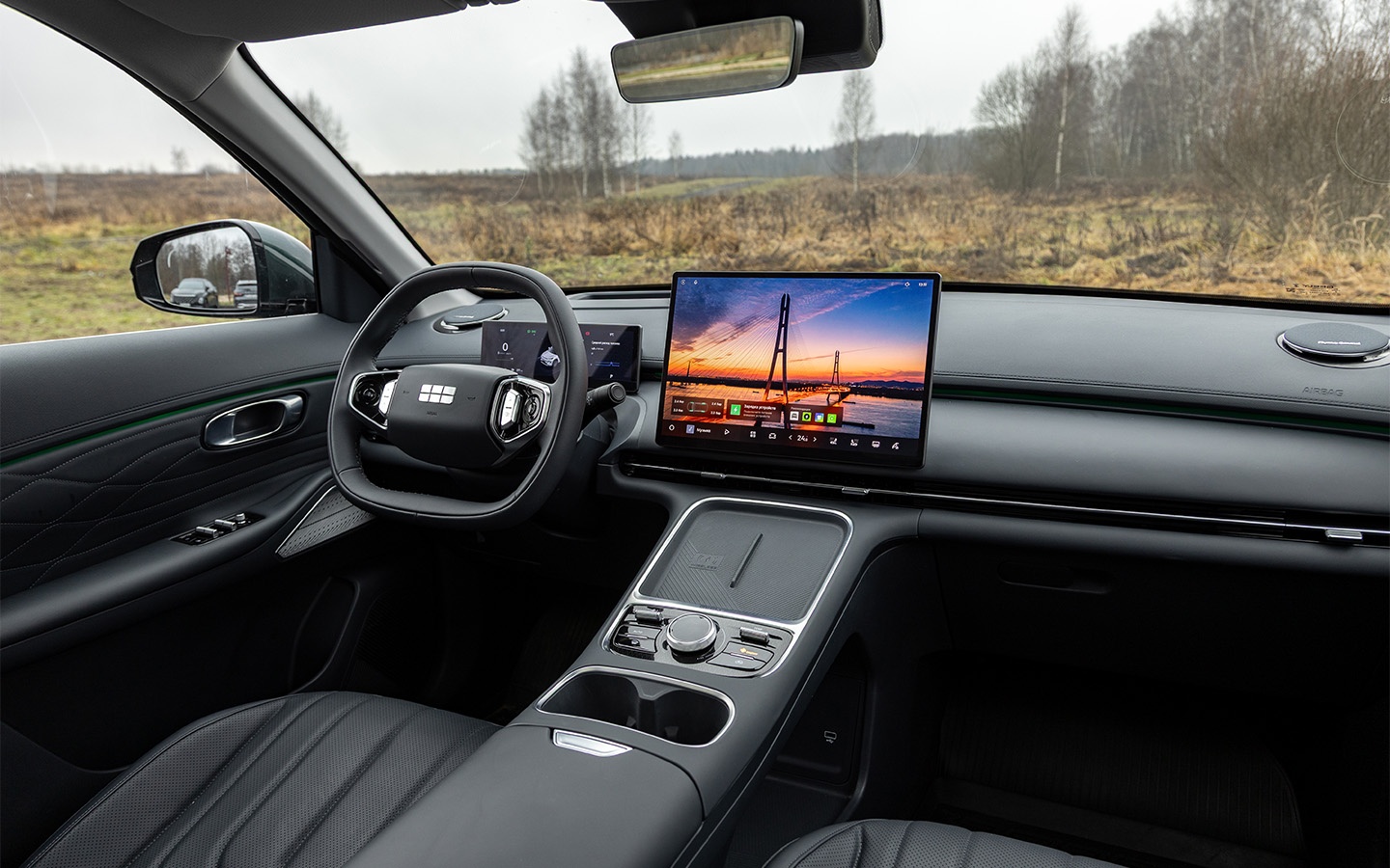 Салон Geely EX5 EM-i похож на оный в электрическом&nbsp;EX5, но и здесь отличий масса. К примеру, площадки для смартфонов&nbsp;переехали в более удобное место, да и вся центральная консоль стала иной&nbsp;