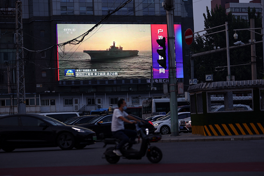 На фото: экран с кадрами кораблей Народно-освободительной армии Китая во время вечерней программы новостей, Пекин, 2 августа