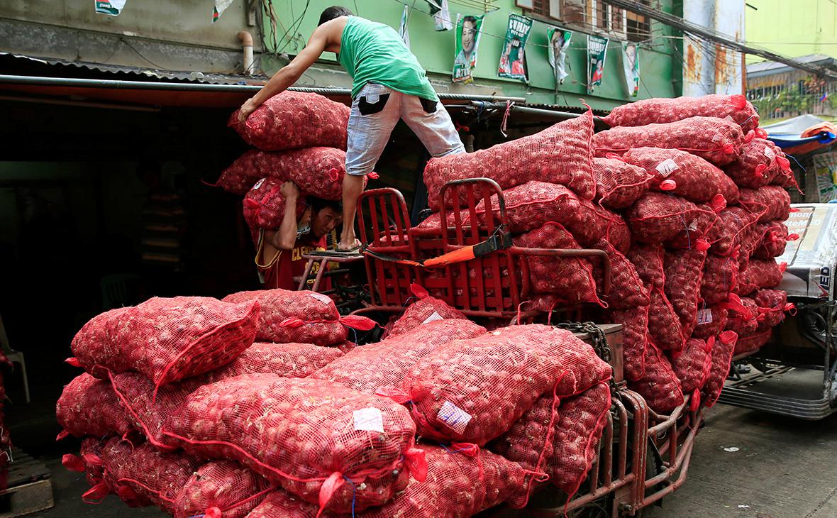 Рабочие&nbsp;грузят мешки с луком, который они доставляют на склад в Маниле, Филиппины