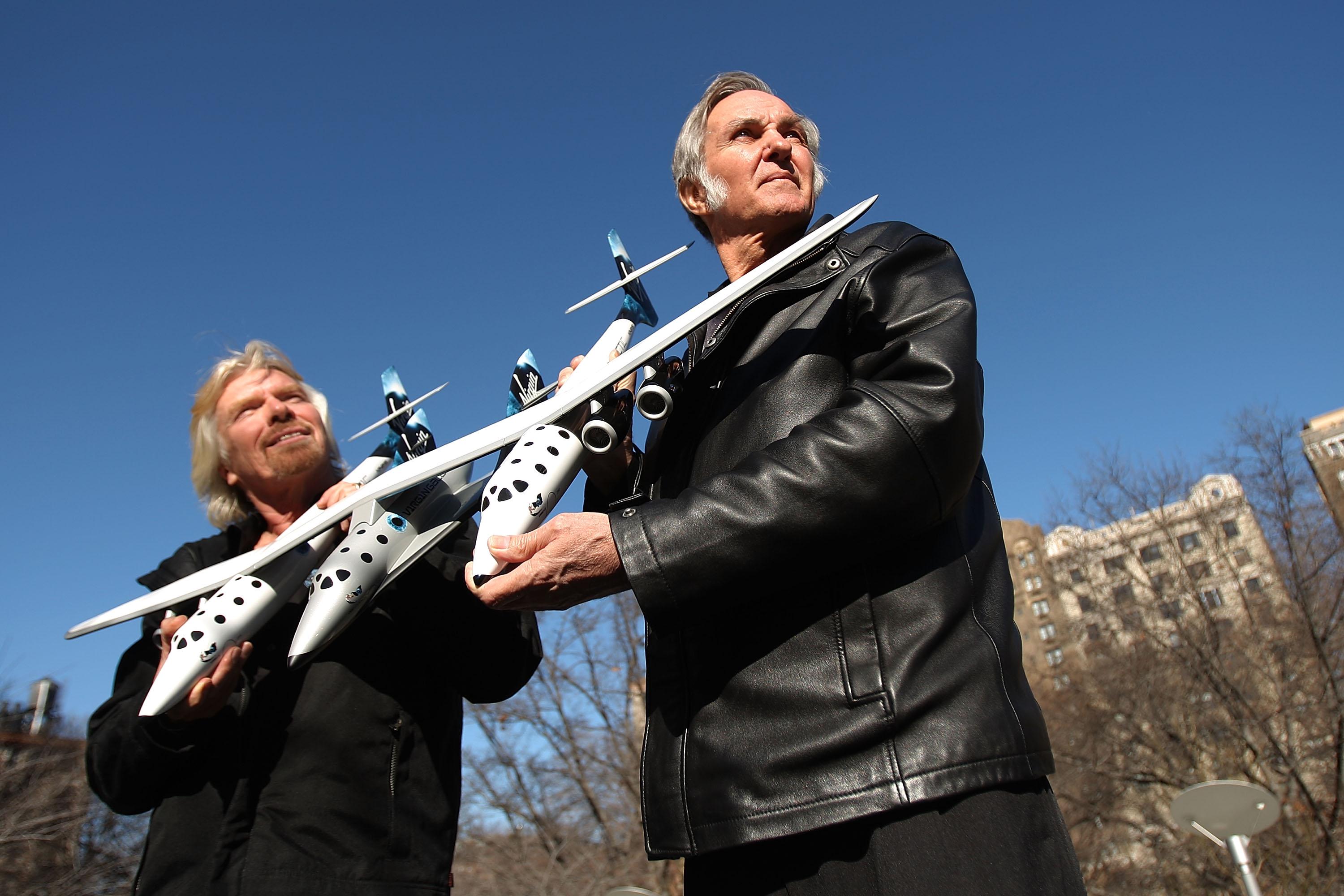 Ричард Брэнсон (слева) и дизайнер Берт Рутан держат модель космического корабля, представленную на пресс-конференции 23 января 2008 года в Нью-Йорке
