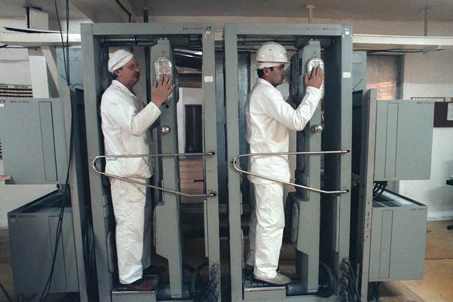 На фото (слева направо): слесарь А. Гринько и заместитель начальника химического цеха Н. Старинец во время проверки на стационарной установке радиационного контроля, октябрь 1992