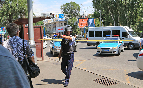 Сотрудник полиции около Алмалинского районного отдела внутренних дел (РОВД) в центре Алма-Аты.&nbsp;​18 июля 2016 года


