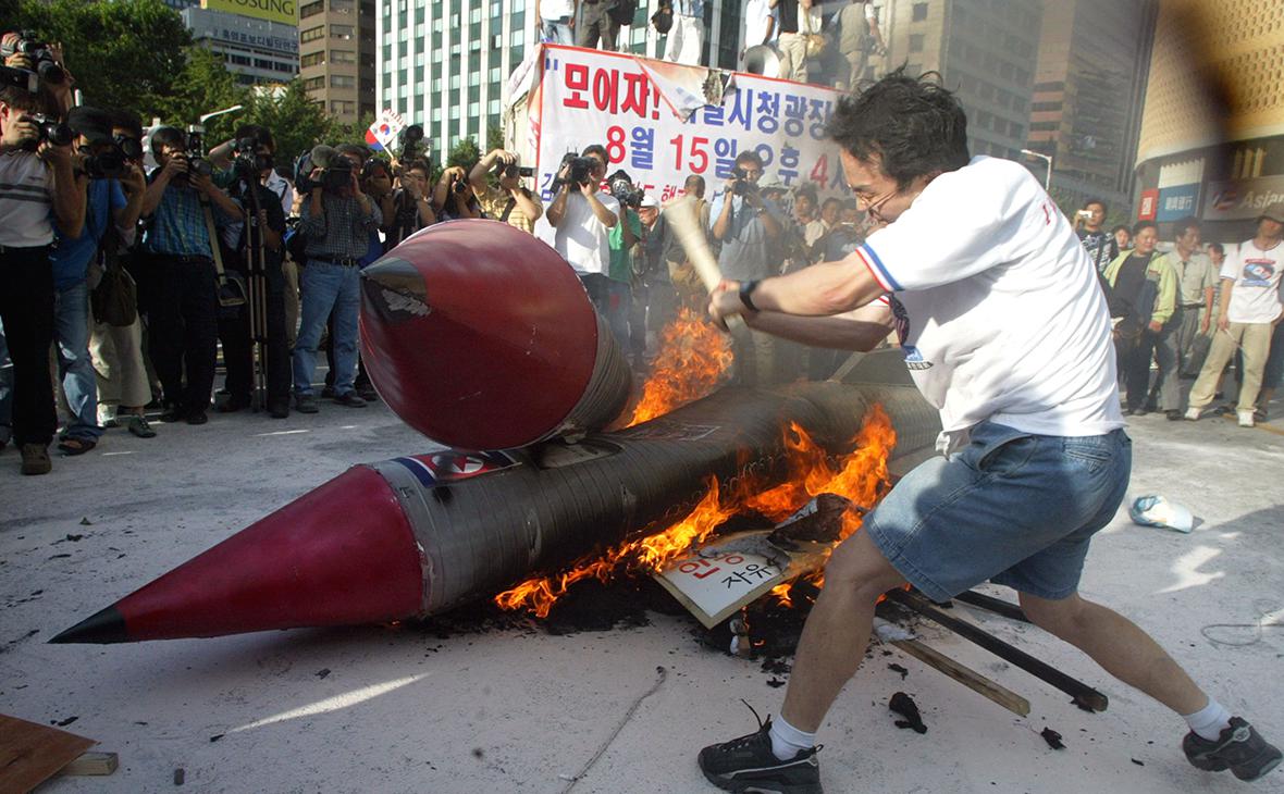 Протестующие против ядерного оружия, сжигают макеты ракет