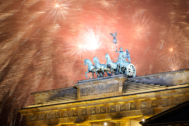 Взрывы фейерверков над Бранденбургскими воротами в Берлине.