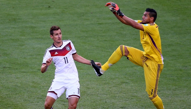 Лучший бомбардир чемпионатов мира Мирослав Клозе сражается за мяч с голкипером сборной Аргентины Серхио Ромеро.