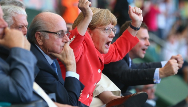 Канцлер Германии Ангела Меркель радуется 4-му голу команды Германии во время матча в Группе G Германия - Португалия. 