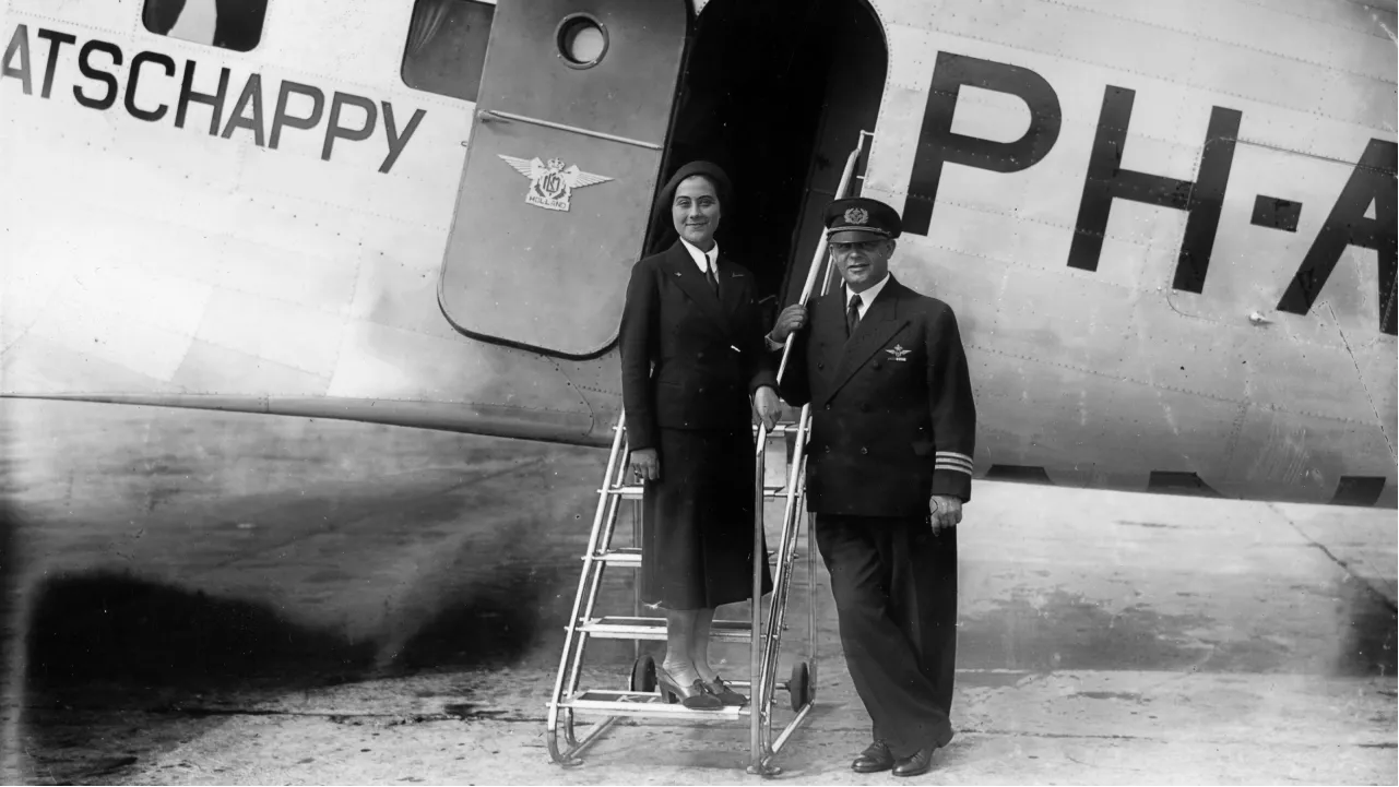 <p>В первые годы существования профессии униформа стюардесс напоминала униформу пилотов &mdash; консервативная, строгая, выдержанная в военной стилистике и вселяющая уверенность и надежность. На фото &mdash; стюардесса и командир борта&nbsp;нидерландской авиакомпании&nbsp;KLM</p>