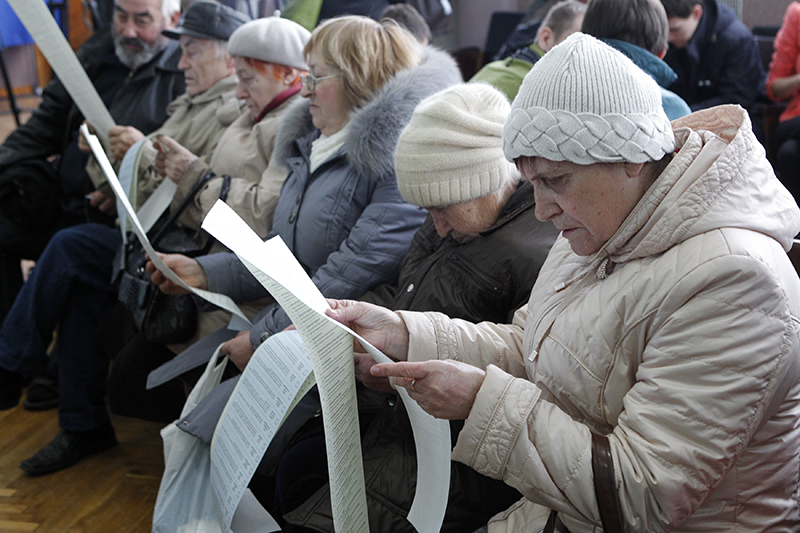 Избиратели просматривают бюллетени на одном из киевских избирательных участков. В новый состав украинского парламента войдут в партии, которые преодолеют пятипроцентный барьер.