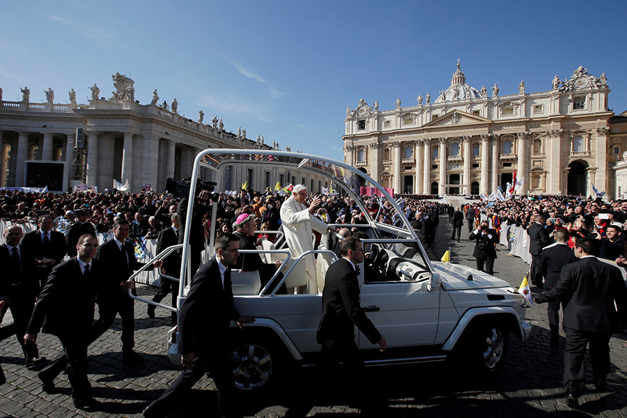 Бенедикт XVI машет верующим после прибытия на площадь Святого Петра, чтобы провести свою последнюю общую аудиенцию в Ватикане