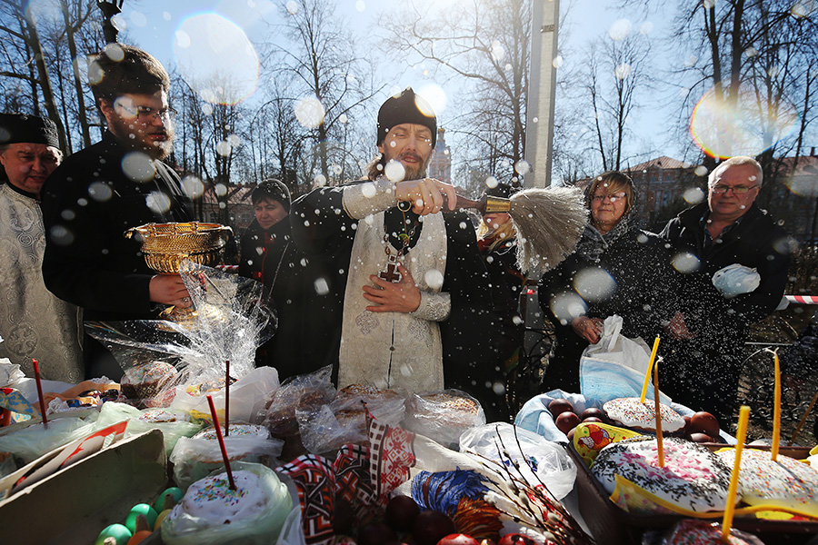 Священник во время освящения пасхальных куличей и яиц в Свято-Троицкой Александро-Невской лавре перед празднованием православной Пасхи. 