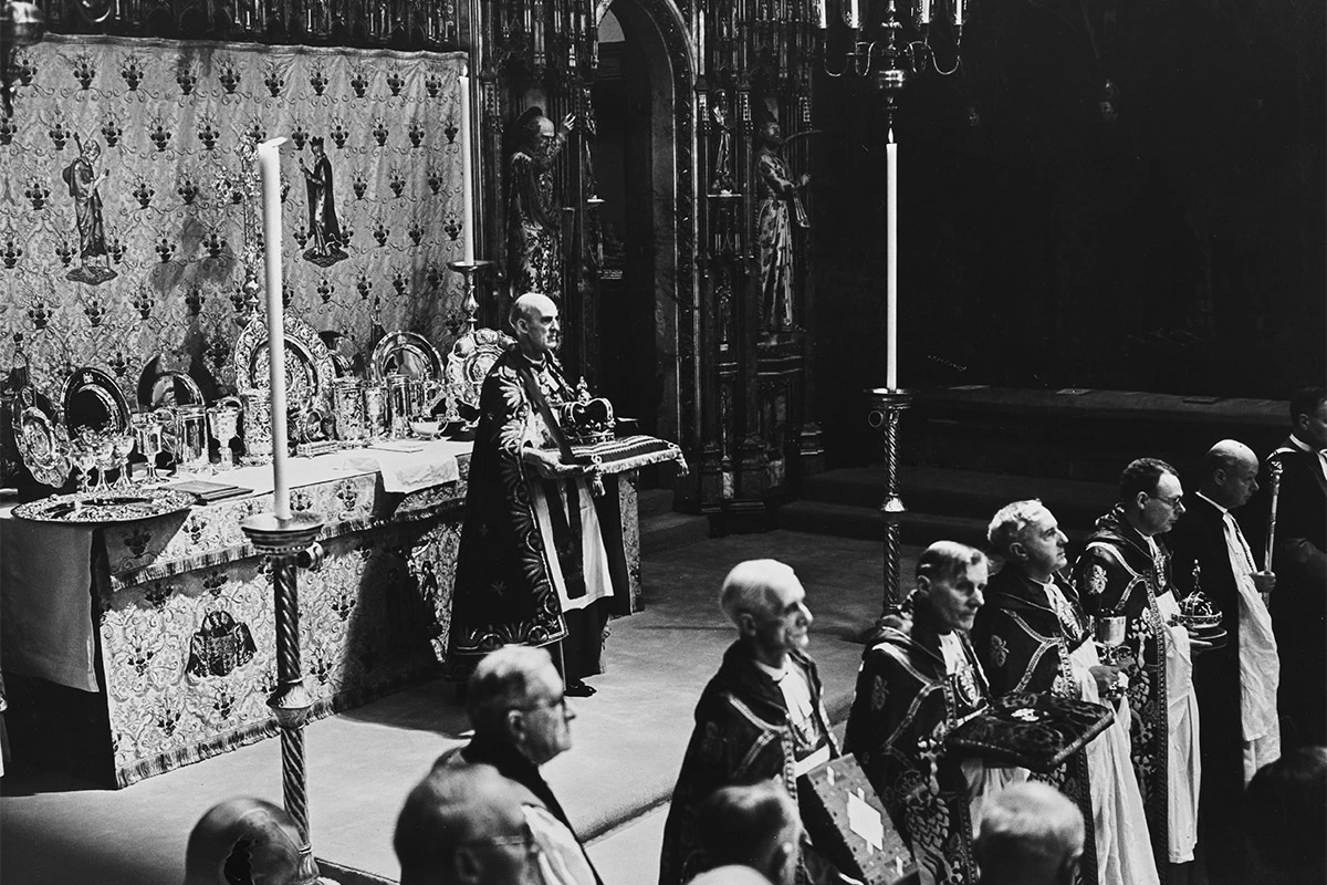 <p>Британский священник Уильям Фоксли Норрис, декан Вестминстера, с короной святого Эдуарда перед алтарем во время коронации Георга VI и королевы Елизаветы в Вестминстерском аббатстве в Лондоне,&nbsp;12 мая 1937 года<br />
&nbsp;</p>
