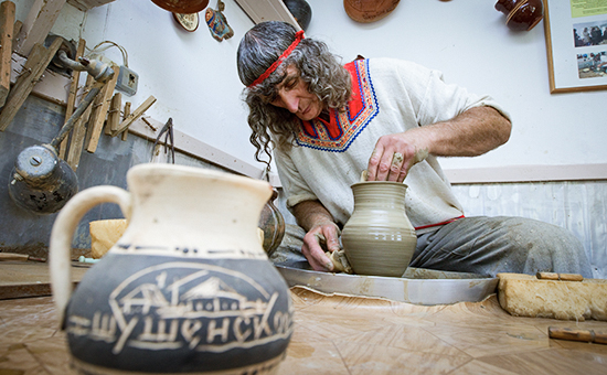 Гончар во время работы в мастерской, расположенной на территории музея-заповедника "Шушенское"
