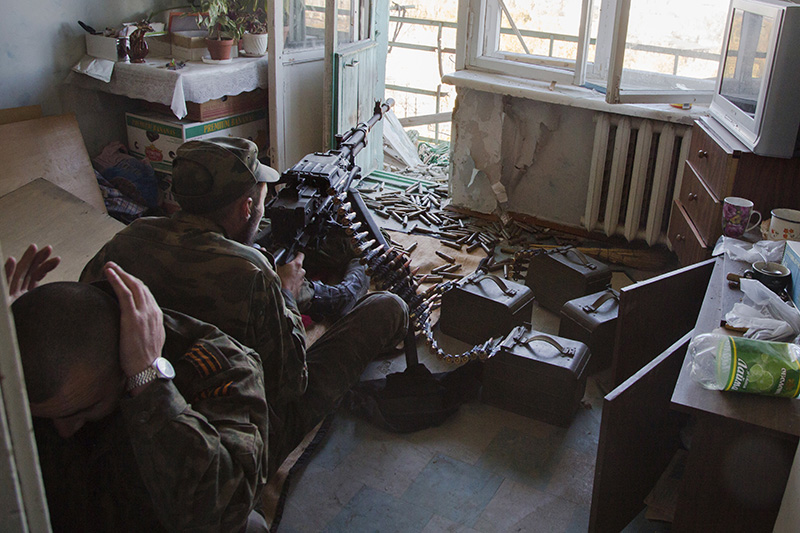 Ополченец ведет огонь по позициям украинских силовиков вблизи аэропорта