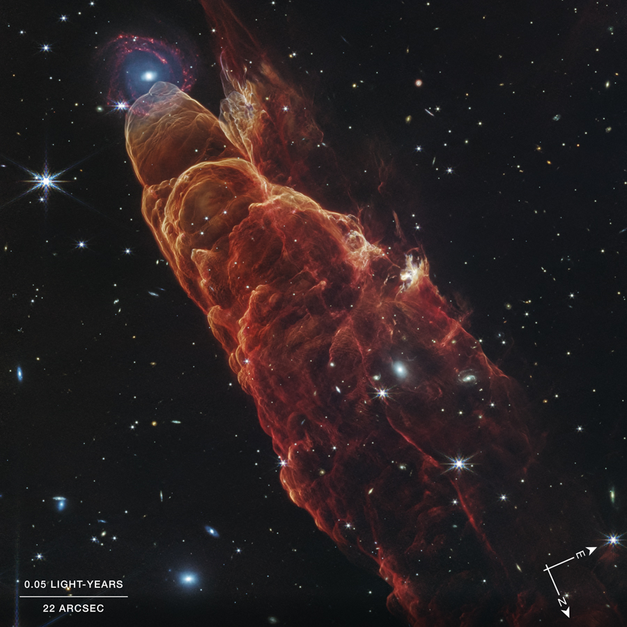 Облако&nbsp;газа и пыли, известное&nbsp;как объект Хербига&nbsp;&mdash; Аро 49/50. На снимке он наложился на изображение спиральной галактики и напоминает &laquo;космический торнадо&raquo;, хотя в реальности галактика находится на расстоянии нескольких световых лет от объекта. Объект Хербига&nbsp;&mdash; Аро&nbsp;&mdash; результат выбросов из близлежащей формирующейся звезды, которая находится за пределами кадра&nbsp;в правом нижнем углу