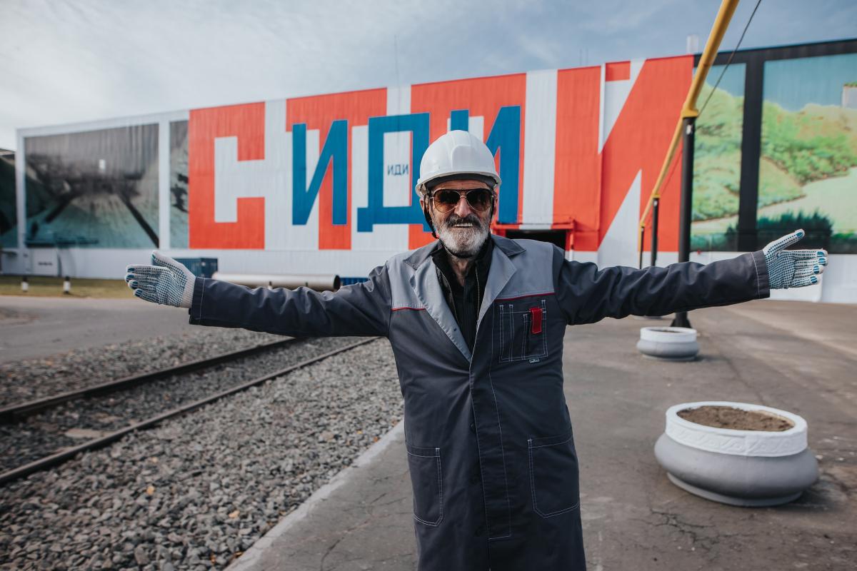 Эрик Булатов на фоне мурала «Стой — Иди. Амбар в Нормандии». 2020 год