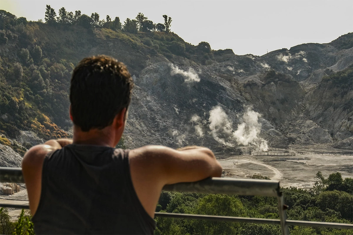 <p>Турист наблюдает за активностью вулкана в одном из кратеров Флегрейских полей</p>