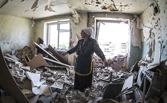 Женщина в квартире, пострадавшей в результате обстрелов в Донбассе