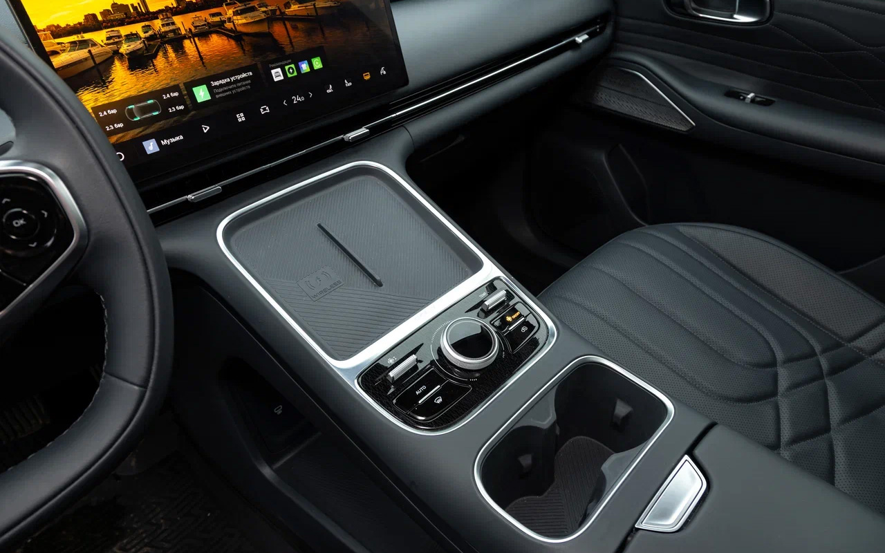 Одно из главных новшеств салона Geely EX5 в гибридной версии EM-i — иная центральная консоль. Теперь подсматривать на экран смартфона действительно удобно