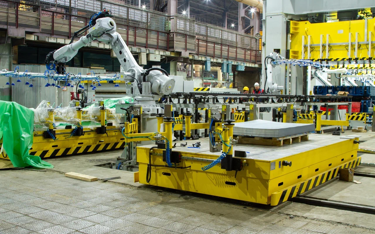 Застали важный момент: роботу прописывают программу подачи листов. Их подвозит автоматическая платформа. Синие «присоски» в руке-манипуляторе — пневмозахваты