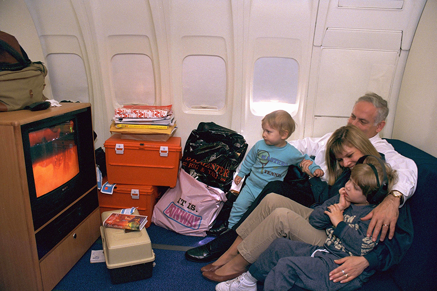 Биньямин Нетаньяху, его жена Сара и их сыновья Авнер (слева) и Яир (справа) смотрят мультфильм на борту самолета ВВС Израиля 1996 год