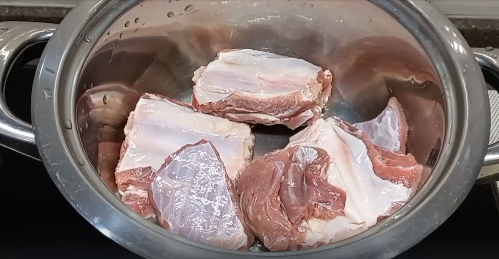 Положите мясо в кастрюлю и залейте водой