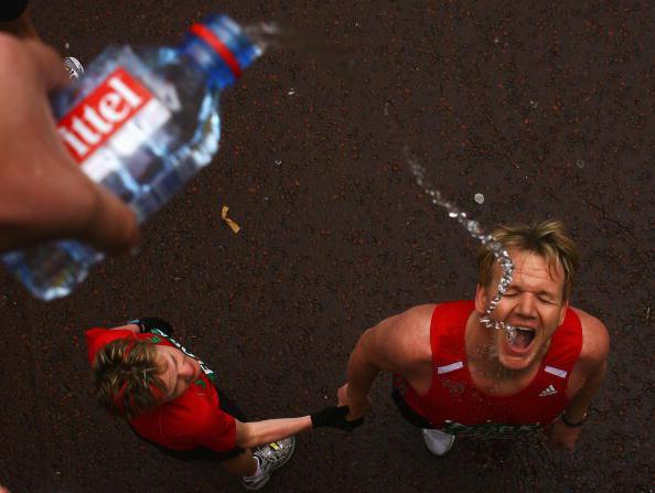 Участник марафона пьет воду