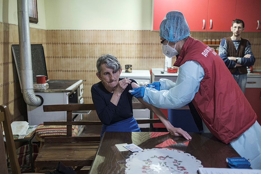 Женщина получает дозу китайской вакцины Sinopharm на кухне своего дома в деревне Лесковик, Сербия, 19 марта