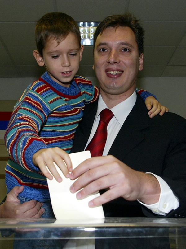 Александр Вучич, кандидат на пост мэра Белграда, на участке для голосования вместе с сыном Данило, 2004 год