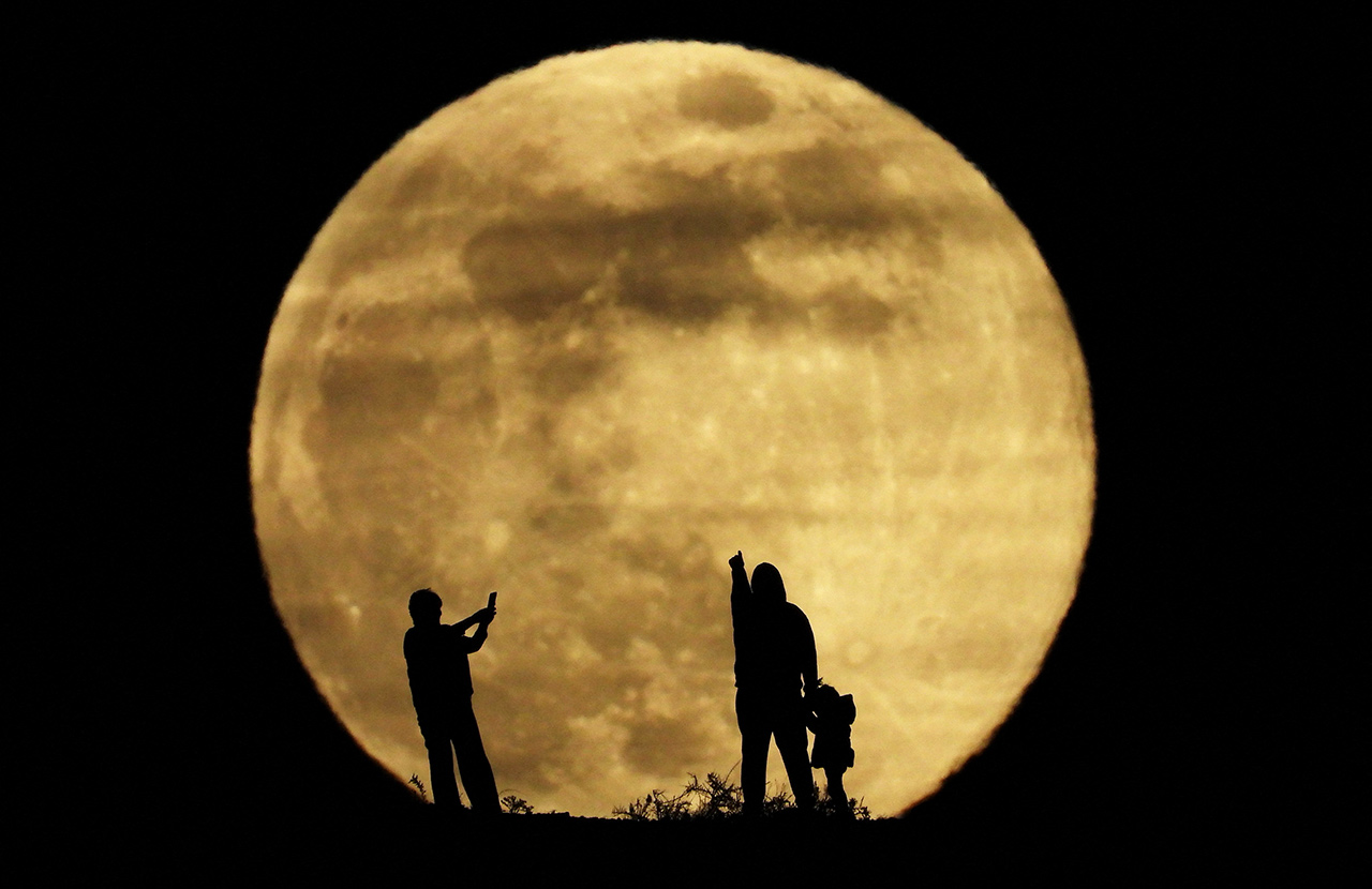 Семья наблюдает за суперлунием на острове Гран-Канария, Испания