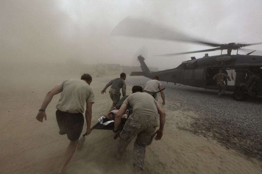 2 августа 2010 года. Спасательная операция, выполняемая командой экспедиционной спасательной эскадрильи ВВС США: военные медики несут раненого солдата афганской армии в эвакуационный вертолет. Провинция Кандагар