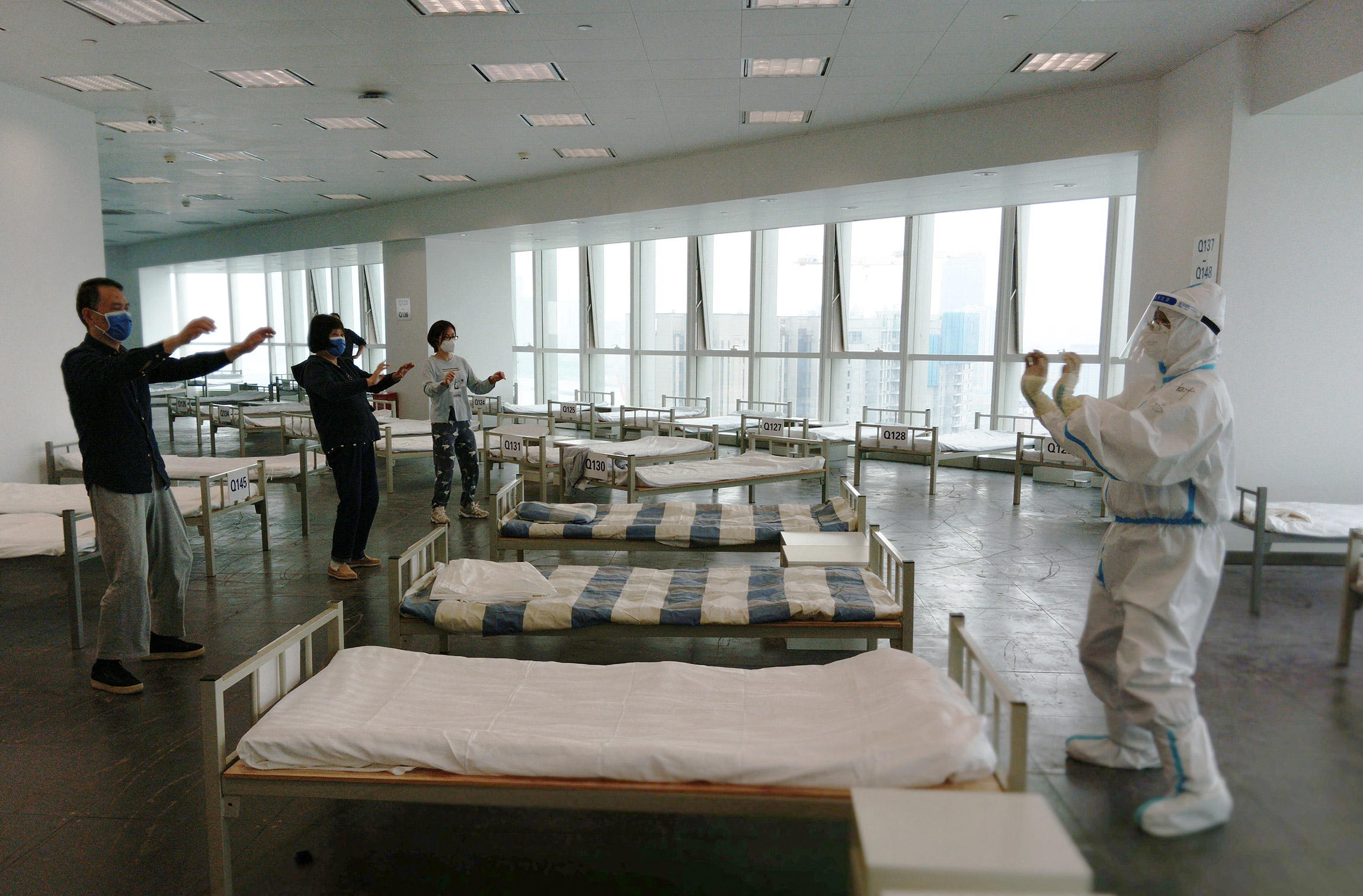 На фото:  врач проводит сеанс тай-чи (дыхательная гимнастика) для пациентов с коронавирусной инфекцией в импровизированном госпитале, 19 апреля