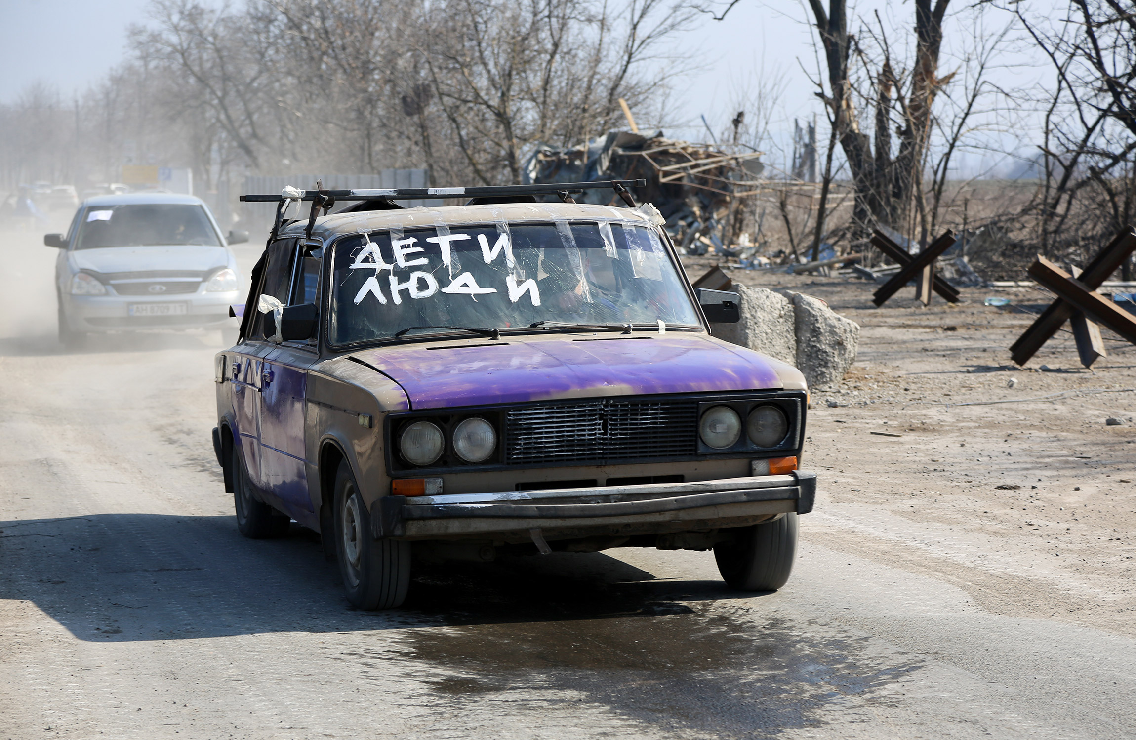 Местные жители во время эвакуации из города, 24 марта.

Люди подписывают машины, чтобы на дороге не оказаться под обстрелом