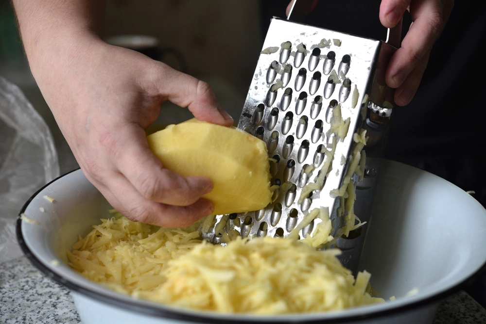 Выжмите тертый картофель и только после этого добавляйте его в фарш